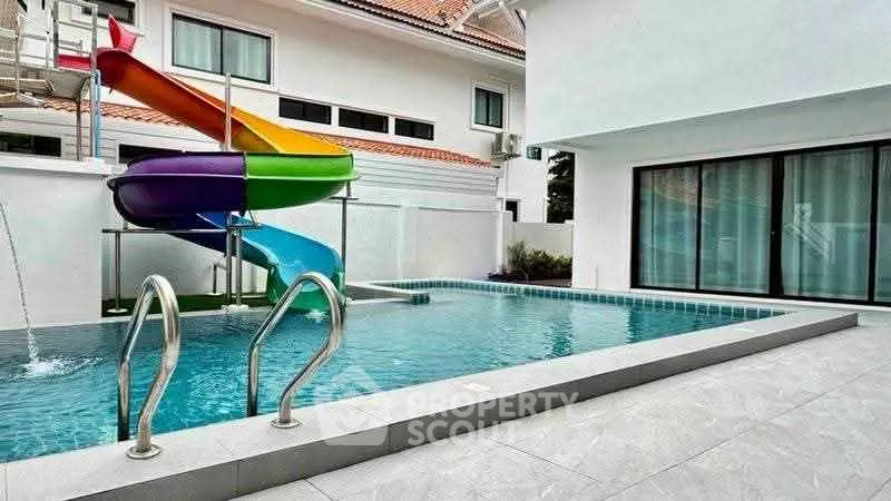 Stunning modern home with private pool and colorful slide, perfect for family fun and relaxation.