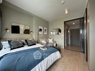 Modern bedroom with stylish decor and cozy seating area in a contemporary apartment.