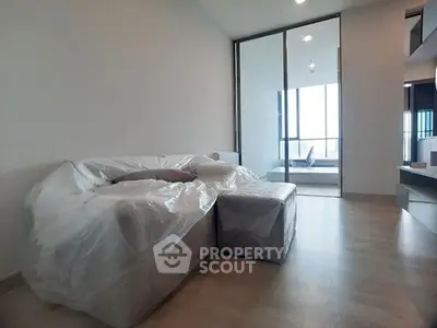 Modern living room with plastic-covered furniture and large windows