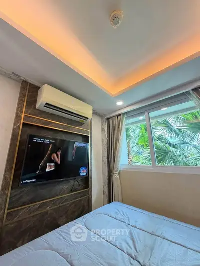 Luxurious bedroom with modern design, featuring a mounted TV and large window with lush greenery view.
