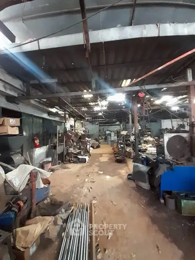 Industrial warehouse space with machinery and storage, ideal for manufacturing or workshop use.