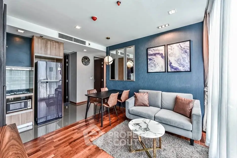 Modern living room with stylish decor, open kitchen, and elegant dining area in a contemporary apartment.