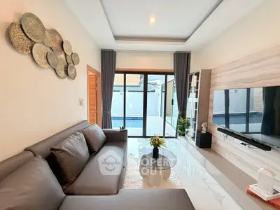 Modern living room with pool view, sleek furniture, and stylish decor in a luxury home.