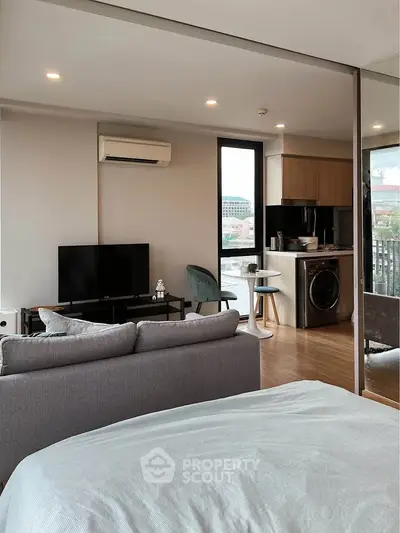 Modern open-plan living room with kitchen and balcony view