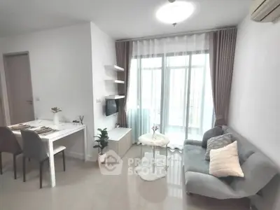 Modern living room with cozy seating and dining area, featuring large windows and elegant decor.