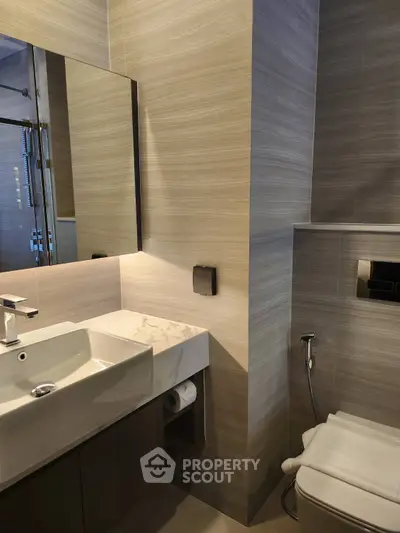 Modern bathroom with sleek fixtures and elegant design, featuring a stylish sink and toilet.