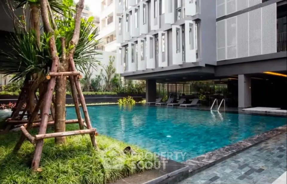 Luxurious modern apartment complex with a stunning outdoor pool and lush greenery.