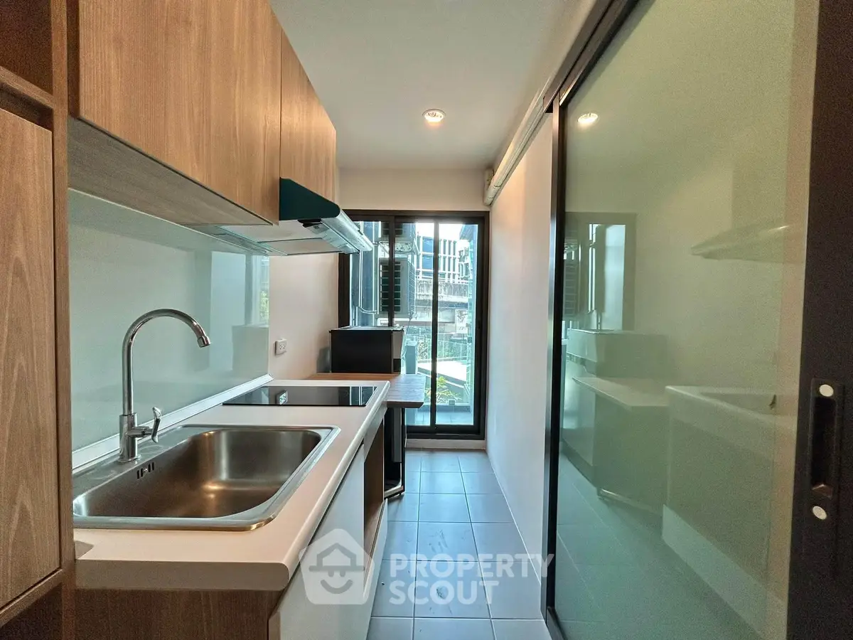 Modern kitchen with sleek design and large window offering natural light.