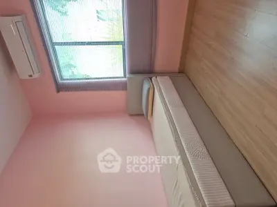 Cozy minimalist bedroom with single bed and air conditioning, perfect for relaxation.