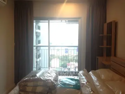 Cozy bedroom with balcony offering city view in modern apartment