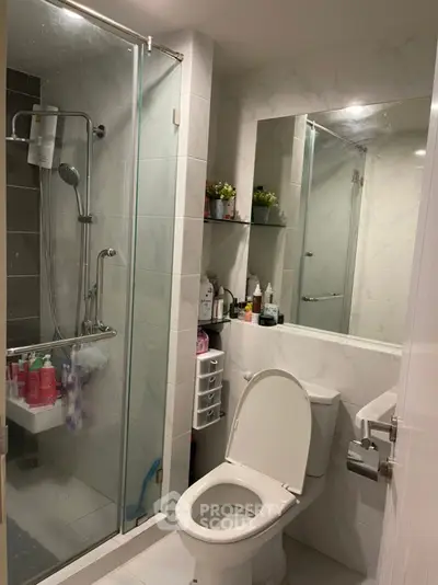 Modern bathroom with glass shower and sleek fixtures in a contemporary apartment.