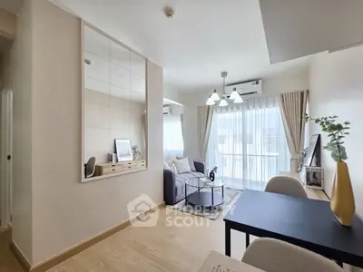 Modern living room with stylish decor, large window, and cozy seating area in a bright apartment.
