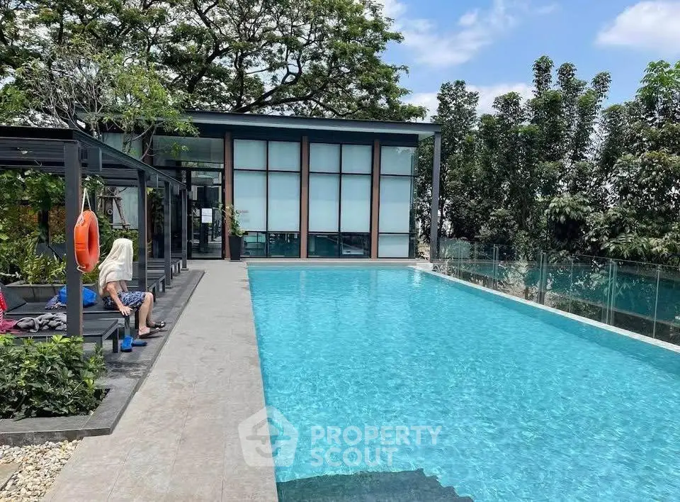 Luxurious outdoor pool area with modern design and lush greenery, perfect for relaxation and leisure.