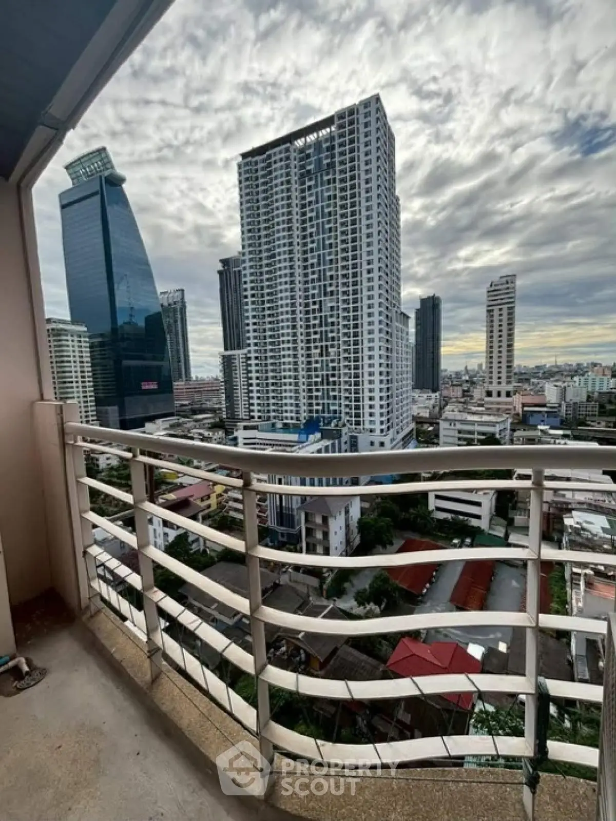 Stunning cityscape view from high-rise balcony with modern skyscrapers.