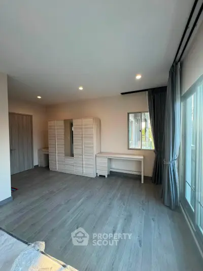 Spacious bedroom with modern wardrobe and large windows for natural light