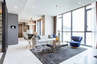 Luxurious modern living room with large windows and elegant furnishings in a high-rise apartment.