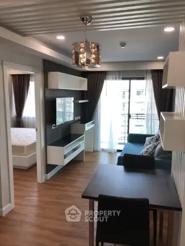 Modern living room with stylish decor and balcony view in a contemporary apartment.