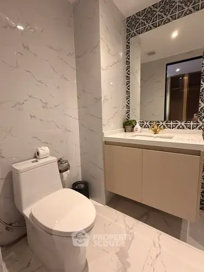Modern bathroom with elegant marble tiles and stylish vanity in a contemporary apartment.