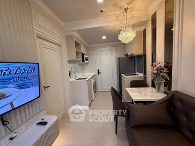 Modern living room with elegant chandelier and open kitchen layout in a stylish apartment.