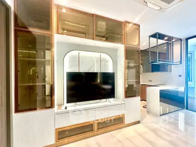 Luxurious modern living room with sleek built-in entertainment center and open kitchen layout.