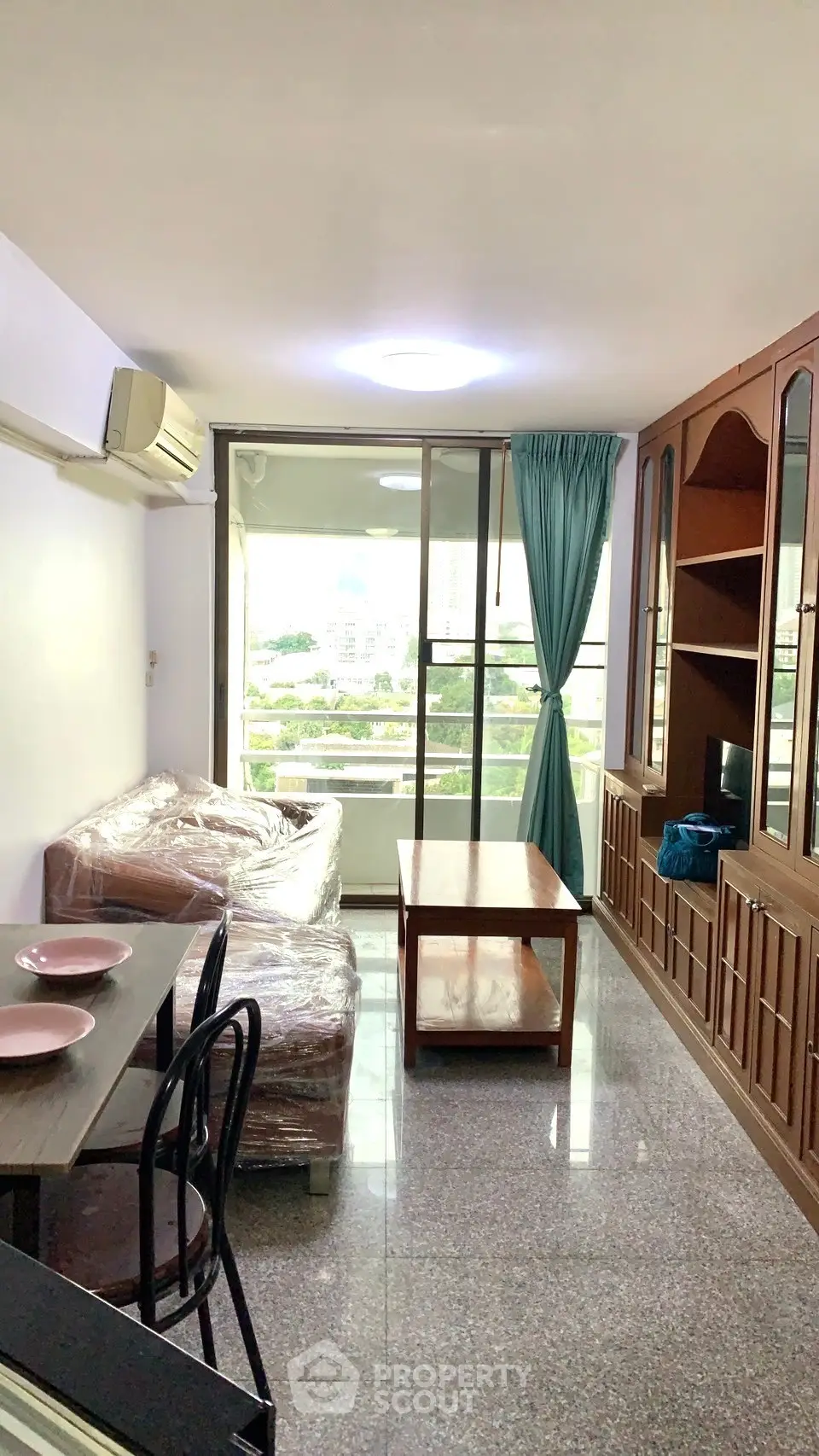 Cozy living room with balcony view, featuring modern furniture and natural light.