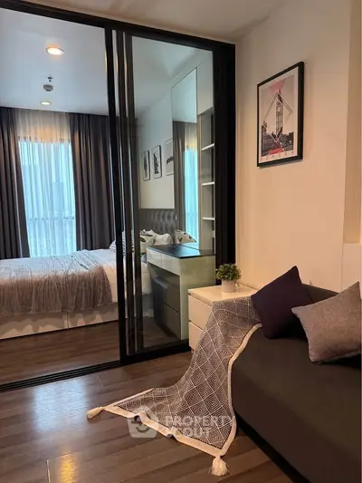 Modern bedroom with glass partition and stylish decor in a cozy apartment.
