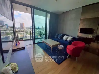 Modern living room with stunning city view from large balcony, featuring stylish furniture and wooden flooring.