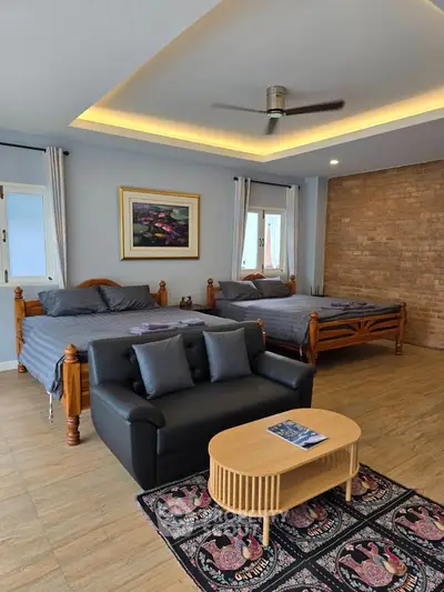 Spacious bedroom with two beds, cozy seating area, and stylish decor.