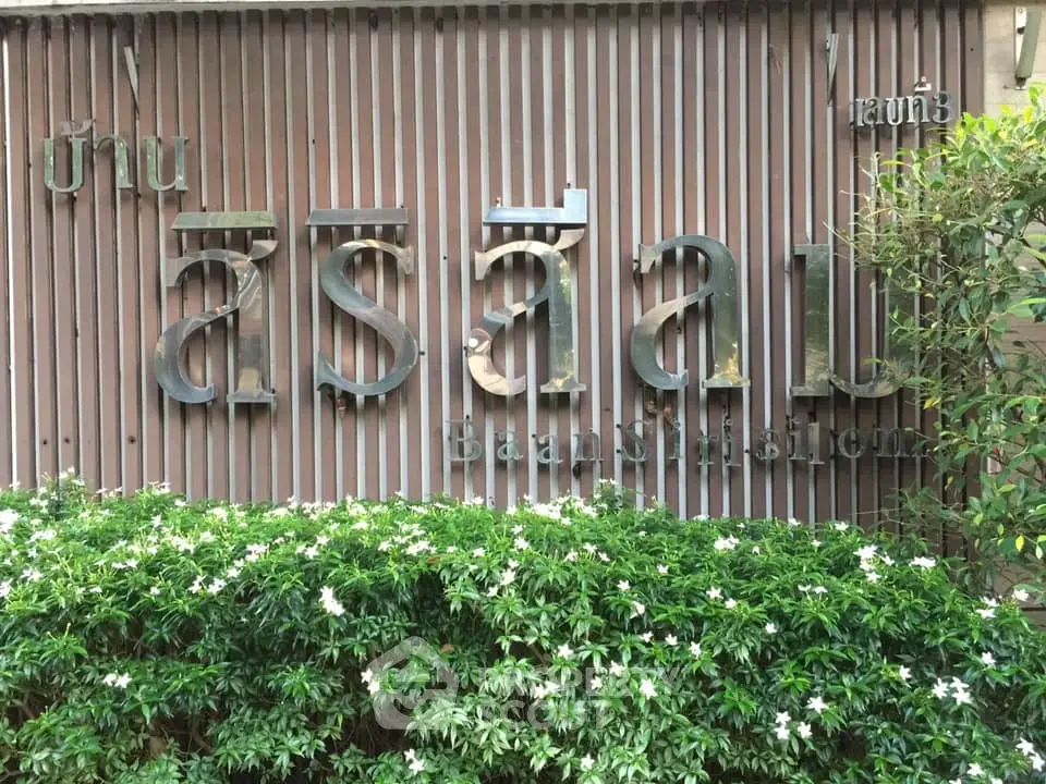 Baan Siri Sathorn entrance with lush greenery and stylish signage.