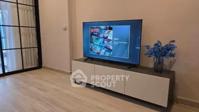 Modern living room with sleek TV stand and large flat-screen TV, perfect for entertainment.