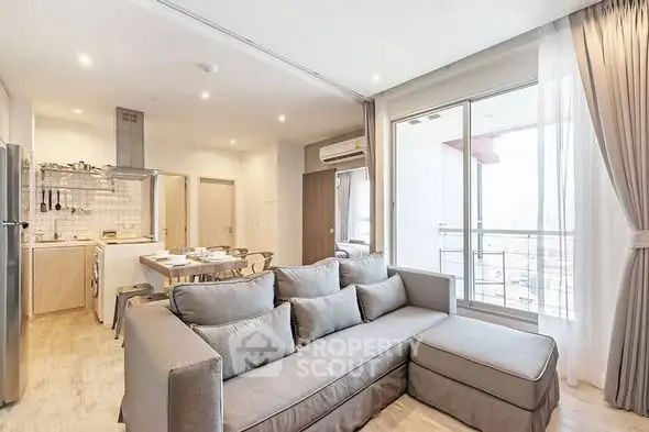 Spacious modern living room with open kitchen and balcony view