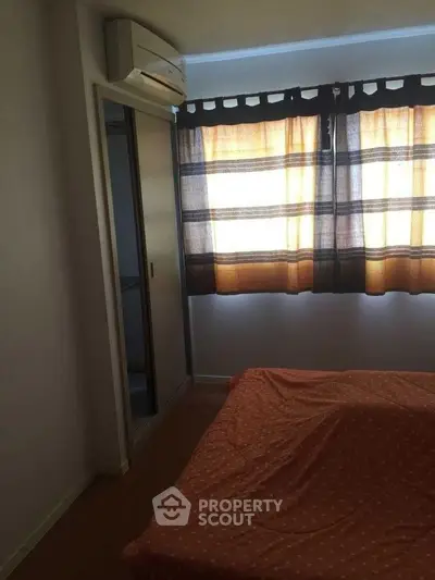 Cozy bedroom with air conditioning and natural light through stylish curtains.