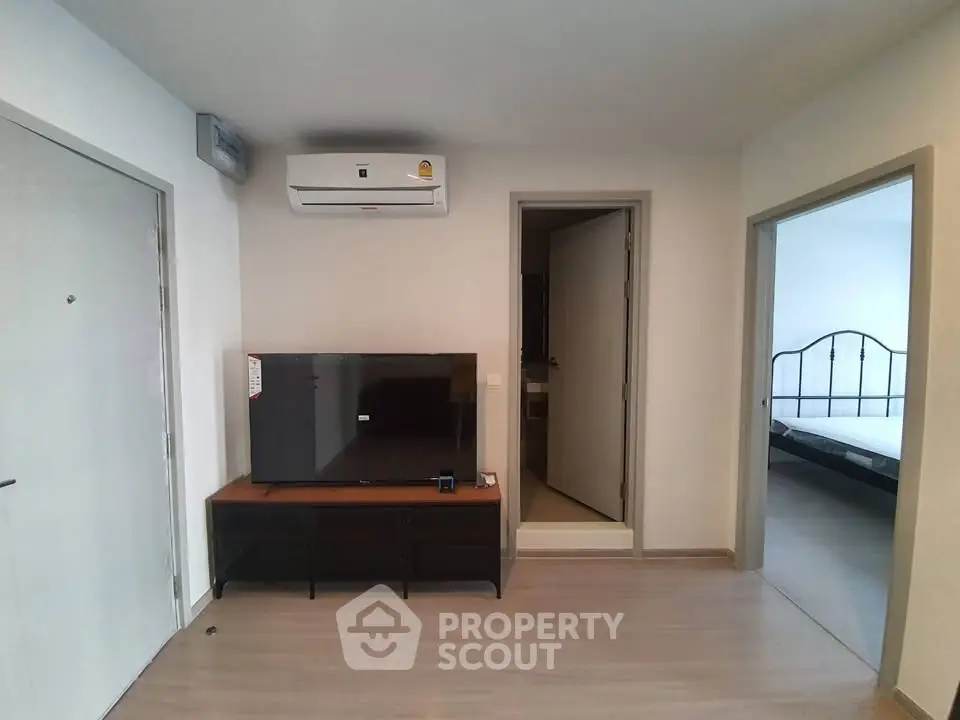 Modern living room with sleek TV setup and air conditioning in a stylish apartment.