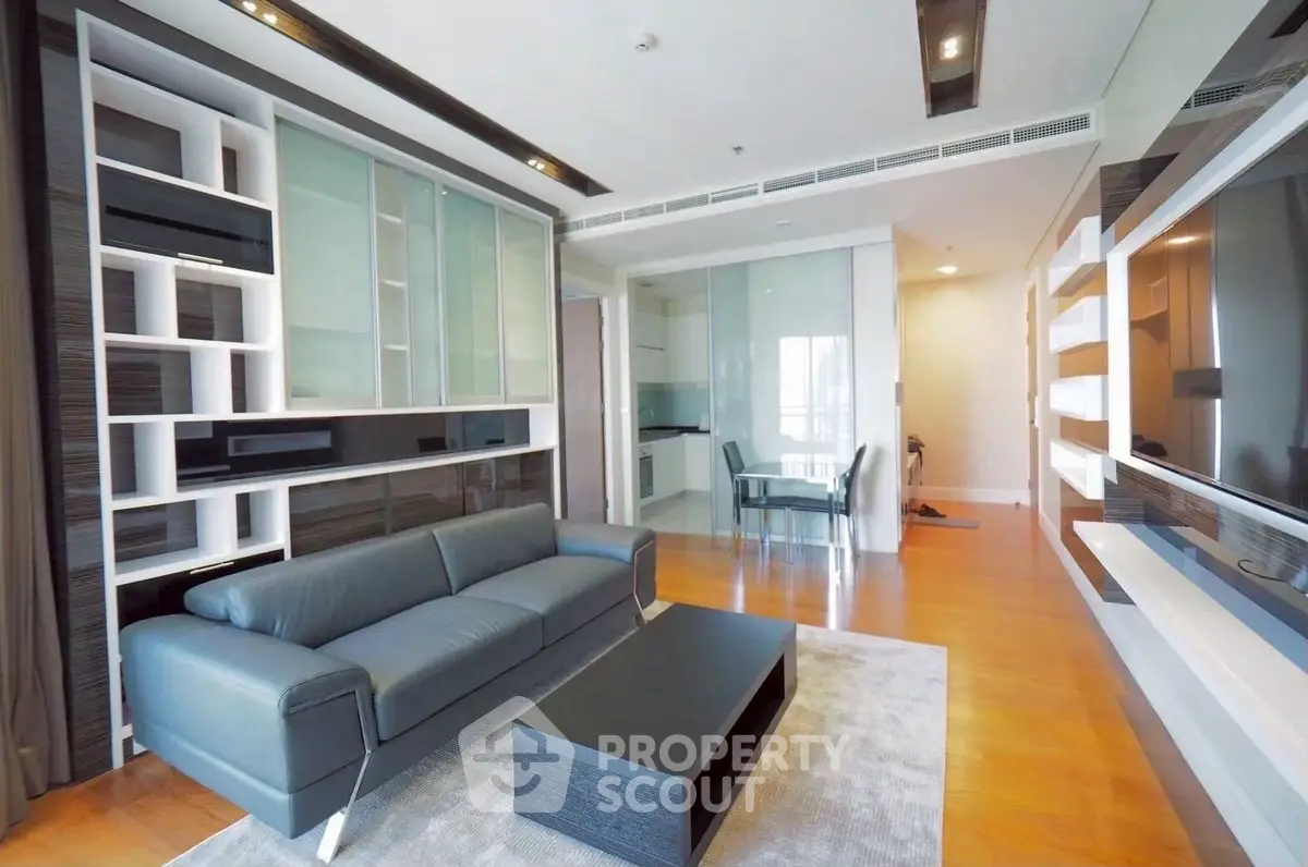 Modern living room with sleek furniture and open layout, featuring a stylish sofa and built-in shelving.