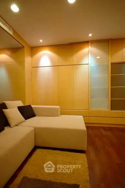 Modern living room with cozy beige sofa and wooden paneling