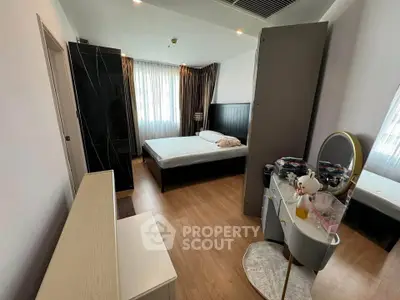 Spacious bedroom with modern furnishings and ample natural light in a stylish apartment.