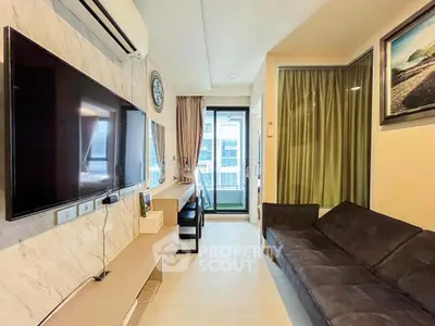 Modern living room with sleek TV and cozy sofa, leading to a balcony with city views.