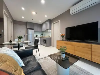 Modern living room with open kitchen, sleek furniture, and air conditioning in a stylish apartment.