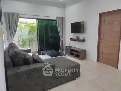 Modern living room with sleek furniture and garden view, perfect for relaxation and entertainment.