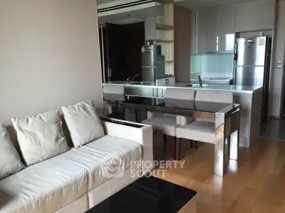 Modern open-plan living room with sleek kitchen and cozy seating area.