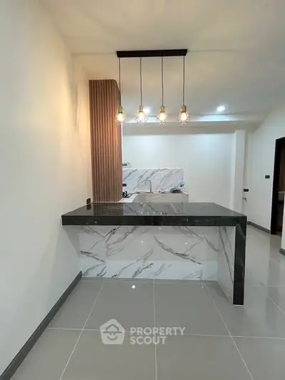 Modern kitchen with marble island and stylish pendant lighting