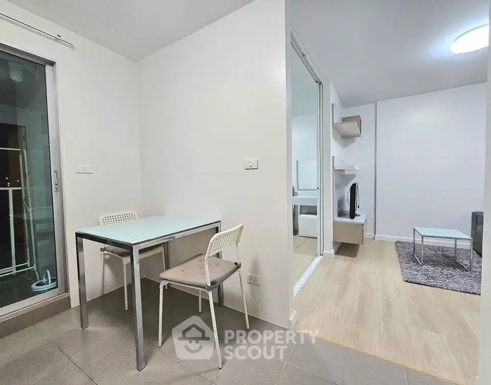 Modern apartment interior with dining area and living room, featuring sleek furniture and neutral tones.