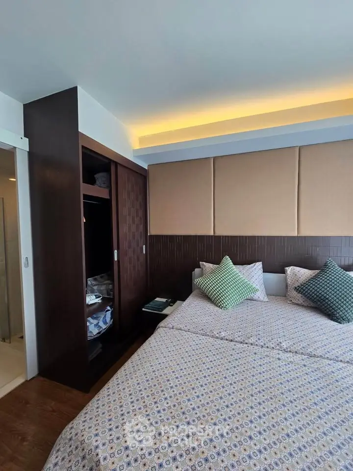 Modern bedroom with stylish decor and built-in wardrobe, featuring cozy bedding and ambient lighting.
