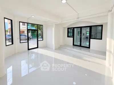 Spacious modern living room with large windows and glossy tile flooring