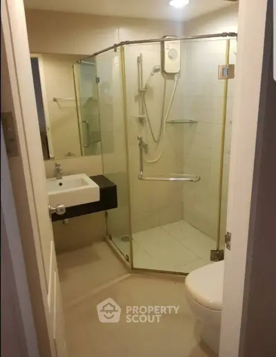 Modern bathroom with glass shower enclosure and sleek fixtures.