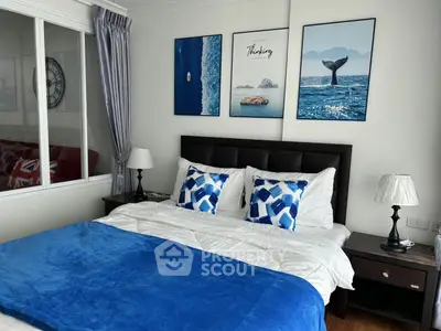 Stylish bedroom with modern decor and blue accents, featuring a comfortable bed and artistic wall art.