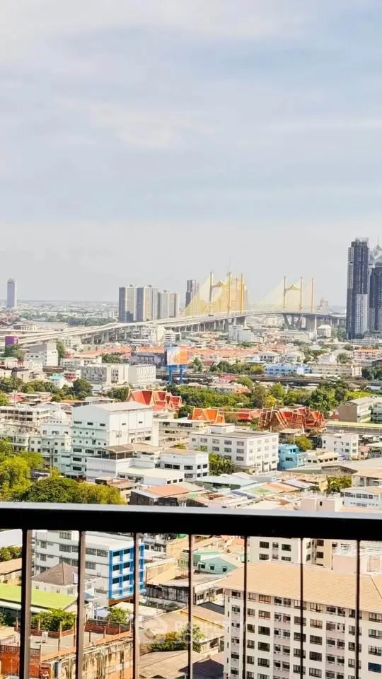 Stunning cityscape view from a high-rise balcony overlooking urban skyline and iconic bridge.