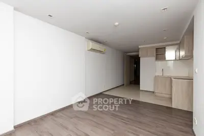 Spacious open-plan living room with modern kitchen and wooden flooring