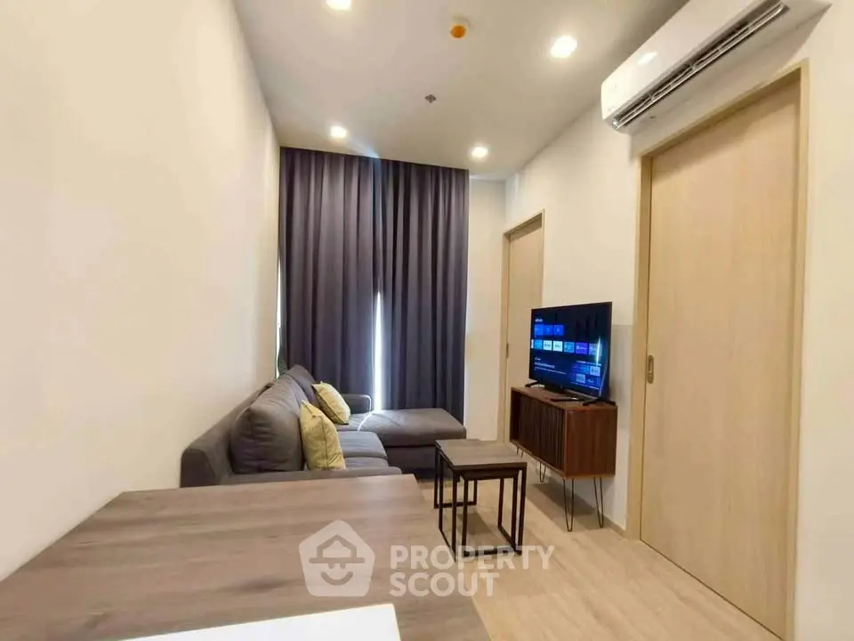 Modern living room with cozy sofa and flat-screen TV, perfect for relaxation.