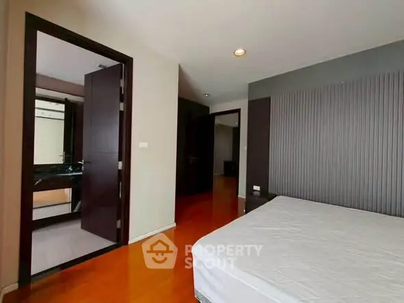 Spacious bedroom with ensuite bathroom in modern apartment